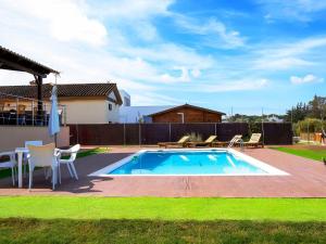 einen Pool mit Stühlen, einem Tisch und einer Terrasse in der Unterkunft Chalet con Piscina Privada Vistas a Campo de Golf in Chiclana de la Frontera