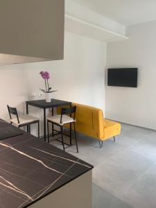 Pokój z żółtą kanapą, stołem i krzesłami w obiekcie Green Home - Bellagio Apt w Como