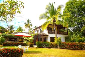 una casa con una palmera, una mesa y una sombrilla en Villas Mamilú. entrada y salida cien por ciento flexible en Santa Fe de Antioquia