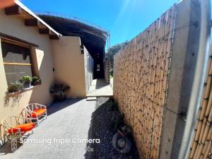 een hek naast een huis met oranje stoelen bij Casa Manipa -3 dormitorios in Cafayate