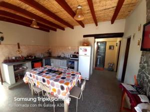 eine Küche mit einem Tisch und einem Kühlschrank im Zimmer in der Unterkunft Casa Manipa -3 dormitorios in Cafayate