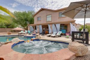 a house with a swimming pool in front of a house at Maricopa Desert Oasis Fenced Yard with Hot Tub in Maricopa