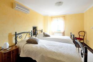 a bedroom with two beds and a air conditioner at Casa Luisa in Livade