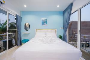 a bedroom with a white bed with blue walls and windows at Di Pool Villa Hunhin 2km from beach in Hua Hin +58 photos