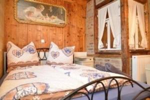 クリンゲンタールにあるSchöne Wohnung in Klingenthal mit Garten, Grill und Terrasseのベッドと壁に絵が飾られた寝室