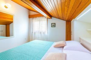 een slaapkamer met een bed en een houten plafond bij Ferienwohnung für 5 Personen ca 50 qm in Crikvenica, Kvarner Bucht Crikvenica und Umgebung in Crikvenica