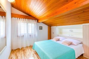 een slaapkamer met een blauw bed en een houten plafond bij Ferienwohnung für 5 Personen ca 50 qm in Crikvenica, Kvarner Bucht Crikvenica und Umgebung in Crikvenica