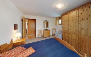 1 dormitorio con 1 cama y pared de madera en Surpunt 44 en St. Moritz