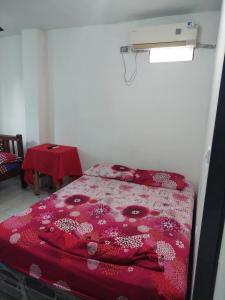 Hotel Unico City في سانتا مارتا: غرفة نوم مع سرير مع لحاف احمر