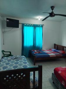 Hotel Unico City في سانتا مارتا: غرفة نوم بها سريرين ومروحة سقف +24 صورة