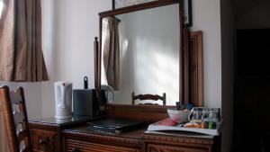 uma cómoda de madeira com um espelho em cima em True Lovers Knot em Blandford Forum