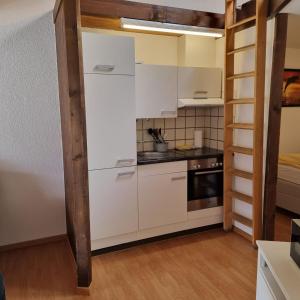cocina con armarios blancos y fogones en Brienz Strasse en Interlaken