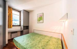 1 dormitorio con 1 cama en una habitación con ventana en L'Aiguille - maeva Home - 2 Pièces 5 Personnes Confort 76 en Chamonix-Mont-Blanc