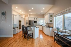 a large kitchen with white cabinets and a wooden floor at Scenic Hills in North Salt Lake