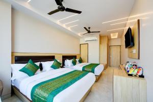 a hotel room with two beds and a flat screen tv at Hotel Express 66 - New Delhi Railway Station in New Delhi