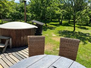 une table et des chaises sur une terrasse avec un bain à remous dans l'établissement Siedlisko Bolek, à Nadrybie