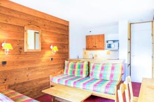 ein Wohnzimmer mit einem Sofa und einem Tisch in der Unterkunft Les Résidences de Valmorel - maeva Home - 2 Pièces 5 Personnes Confort 77 in Valmorel