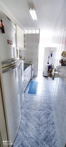 uma cozinha com electrodomésticos brancos e piso em azulejo azul em Ap a 50m da Prainha em Arraial em Arraial do Cabo