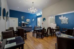 een eetkamer met blauwe muren en tafels en stoelen bij The Wescoe Guesthouse in Blackpool