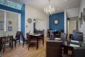 a restaurant with tables and chairs and a clock on the wall at The Wescoe Guesthouse in Blackpool