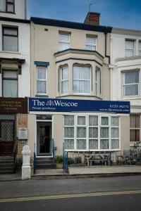 a white building with a blue sign on it at The Wescoe Guesthouse in Blackpool