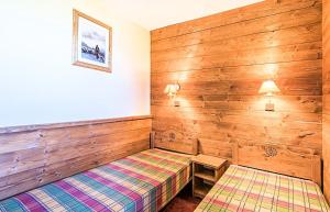 2 Betten in einem Zimmer mit Holzwänden in der Unterkunft Les Résidences de Valmorel - maeva Home - 2 Pièces 5 Personnes Confort 79 in Valmorel