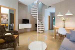 un salon avec un escalier en colimaçon et une table dans l'établissement Apartamentos Alberto Lista 9, à Séville