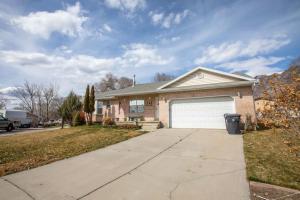 a brick house with a garage and a driveway at Duke's Hawaiian Surf Haven in Pleasant Grove