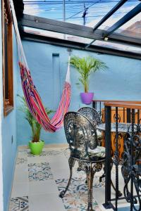 eine Terrasse mit 2 Stühlen und einer Hängematte auf einer Veranda in der Unterkunft Casa Moline Blue in Bogotá