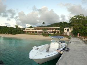 a boat is docked in the water next to a beach at Beautiful Honeymoon Suite at Sunset Serenade in Enighed