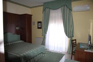 sypialnia z łóżkiem i oknem w obiekcie Hotel Ristorante Thomas w mieście Torregrotta