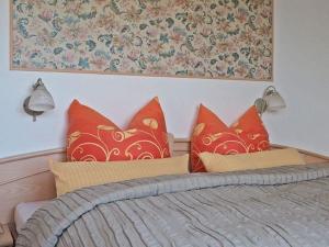 um quarto com uma cama com almofadas vermelhas em Herzlich Willkommen im Vier Jahreszeiten Gäste Apartments Bad Steben em Bad Steben