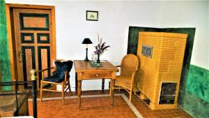 Zimmer mit einem Schreibtisch, Stühlen, einem Tisch und einer Tür in der Unterkunft Saniertes historisches Fischerhaus Godewind rechte Haushälfte mit Studio in Altwarp