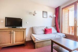 een woonkamer met een bank en een flatscreen-tv bij Résidence L'Albane - maeva Home - 3 Pièces 7 Personnes Prestige 03 in Vars