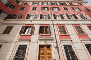 ローマにあるCasa Isideの赤い高い建物(ドア、窓付)