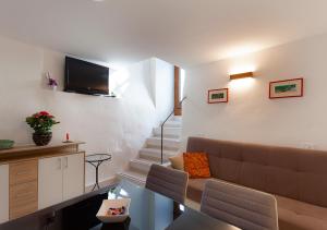 uma sala de estar com um sofá e uma escada em Casetta della Posterna em Spoleto
