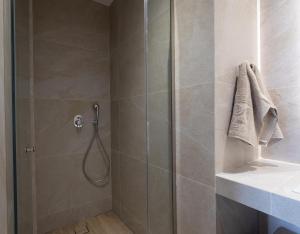 a bathroom with a shower with a glass door at Spitarona Town House - Largest VIlla in the Center in Mýkonos City +52 photos