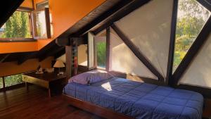 a bedroom with a bed and a table and windows at Cabaña Costa Azul Los Acantilados in Mar del Plata