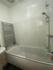 a white bathroom with a tub and a sink at Stylish 2 bedroom home in Cleckheaton
