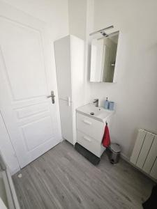 uma casa de banho branca com um lavatório e um espelho em Le Petit Havre de Paix em Le Kremlin-Bicêtre
