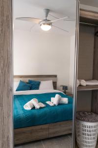 a bedroom with a bed with blue pillows and a mirror at A brand new apartment in Pieta
