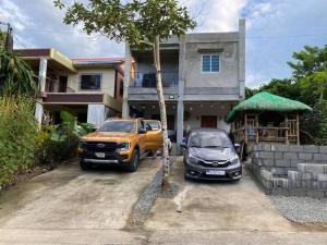 een vrachtwagen en een auto geparkeerd voor een huis bij Room near tagaytay • wifii/Netflix in Tagaytay