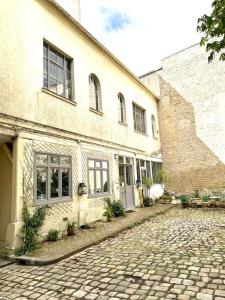 a cobblestone street in front of a building at Sublime Loft à St Germain (3 chambres) in Paris