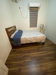 een kleine slaapkamer met een bed en een ventilator bij Room near tagaytay • wifii/Netflix in Tagaytay