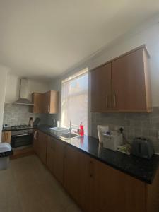 a kitchen with wooden cabinets and a counter top at Stylish 2 bedroom home in Cleckheaton