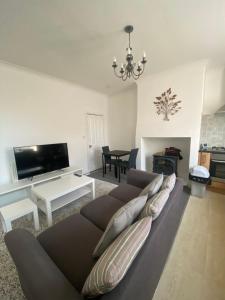 a living room with a couch and a table at Stylish 2 bedroom home in Cleckheaton
