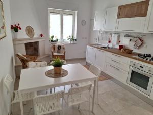 a kitchen with a white table and chairs in a room at Casa Vacanze Al Parco in Casamassima