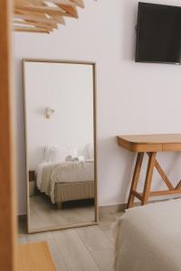 a mirror in a bedroom with a bed and a desk at Pure Fonte Velha B&B in Vila do Bispo
