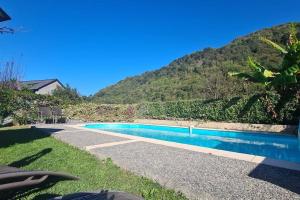 a swimming pool in front of a mountain at Un moment de partage au Gabizos. in Geu +21 photos
