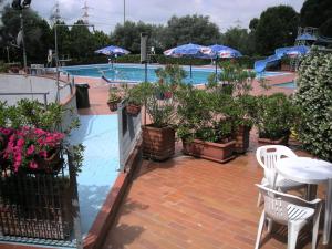 un patio con mesa y sillas junto a una piscina en Hotel Delta Florence en Calenzano